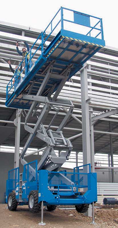 A scissor lift hire platform being used on uneven ground with stabilisers deployed to guarantee the scissor lift work platform is level